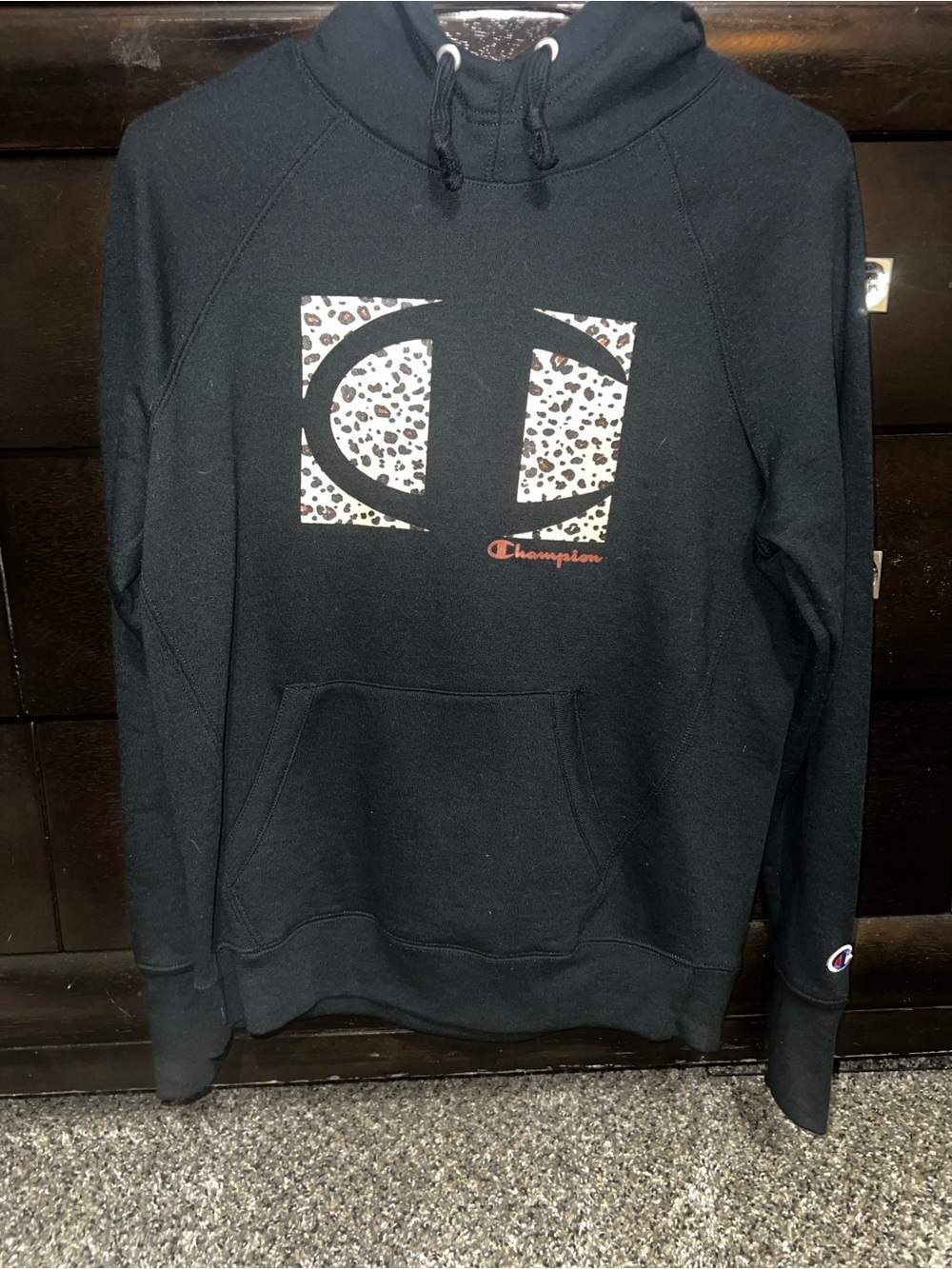 Champion Black Hoodie with Leopard-Print Logo and Orange Script